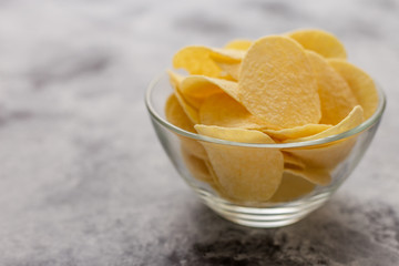 Potato chips in glass bowl.The concept of fast food .