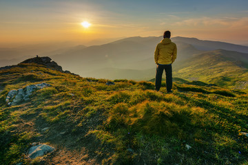 Mountain scenery in the Ukrainian Carpathians in the summer with a tourist in the background of the sunset