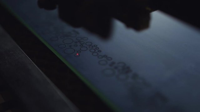 The engraving on the mirror with a laser machine. Burning laser ornament on the mirror.