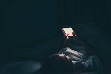 Asian woman playing game on smartphone in the bed at night,Thailand people,Addict social media