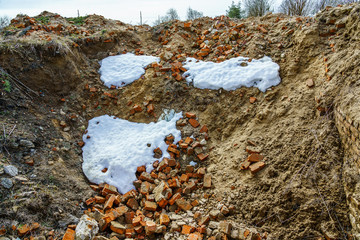 broken brick and snow on the site of the destroyed house