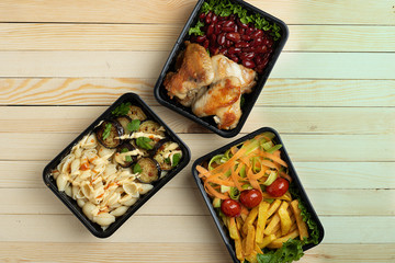 garden raw vegetables with roast chicken, food containers on rustic table, flat lay. Seletive focus