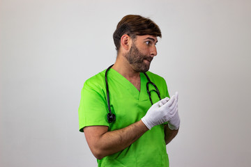 Portrait of male veterinary doctor in green uniform with brown hair looking ashamed, facing...
