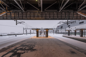 Fototapeta na wymiar Empty railway and platform covered with white snow