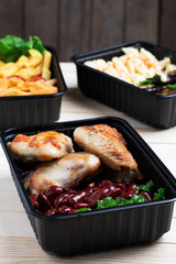 side view of ready meal to eat, roast chicken wings with pasta and cheese, vegetables background