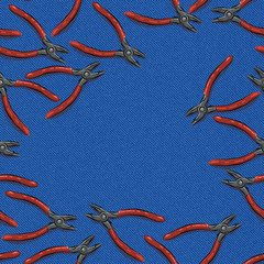 pliers with an orange handle on a blue denim background with a place for text