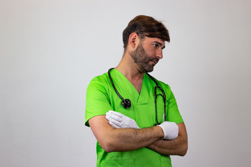 Portrait of male veterinary doctor in green uniform with brown hair bored, facing forwards and looking at the side. Isolated on white background.