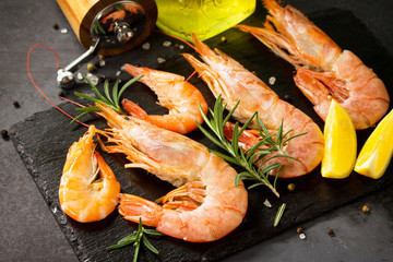 Seafood. Raw shrimps with spice and lemon on a slate board.