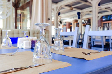 Wonderful restaurant in a loft style. shelves with dishes and equipment. tables ready for clients.Traditional Mediterranean restaurant interior design. Wooden Furniture in the restaurant. Table
