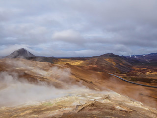 Smoking pools, filled with sulfur seen from above. Thick and dense smoke surrounding the whole area. Geothermal activity region in Iceland, Hverir. Place where you feel the power of the planet.