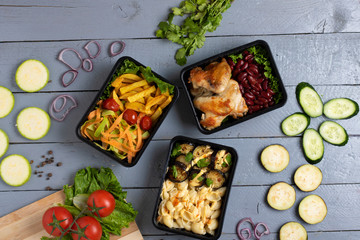 grey background, parsley and micro greens in food containers, zucchini and eggplants