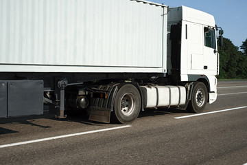 Naklejka na ściany i meble Truck is going along the road. Cargo transportation concept.