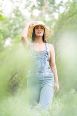 Young woman posing in countryside with hat