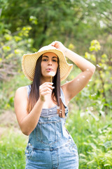 Young woman posing in countryside with hat