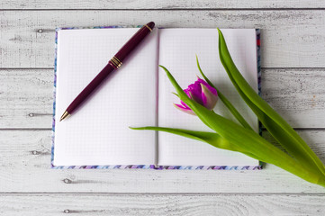 Fototapeta Notatnik na drewnianym stole z  tulipanem  obraz