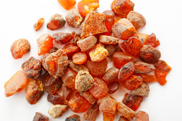 Amber. Many pieces of beautiful red amber on a white background. Polished fossil resin. Natural...