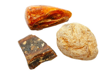 Amber. Three pieces of different types of fossil resin on a white background. Polished ancient petrified resin. Natural mineral. Material for jewelers. Sun stone. Crystal. Semiprecious stone