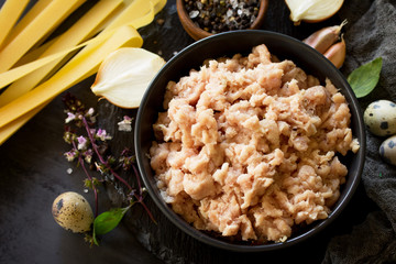 Minced meat and ingredients for cooking minced meat in a bowl on a slate.