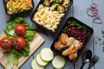 top view above table, baked eggplants and zucchini, grilled chicken wings with cheese pasta on grey table
