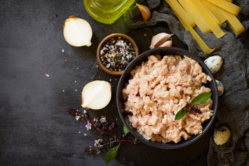 Minced meat, pasta and ingredients for cooking minced meat in a bowl on a slate. Top view flat lay background. Copy space.