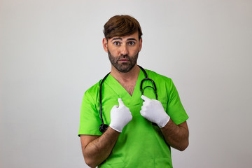 Portrait of male veterinary doctor in green uniform with brown hair looking guilty, looking at the camera. Isolated on white background.