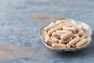 Korean Ginseng capsules. Concept for a healthy dietary supplementation. Rustic wooden background. Close up. Copy space. 