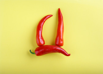 Red chili pepper on yellow background. Top view, flat lay, close-up. Food concept.