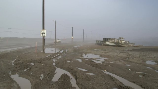 Cars driving on a misty coastal road at Barrow, Alaska