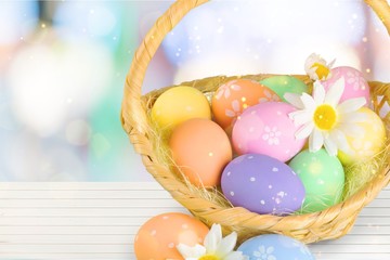 Easter basket filled with colorful eggs on a white background