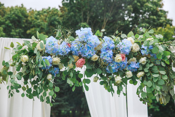 Arch for the wedding ceremony, decorated with cloth and flowers.