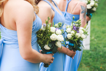 bridesmaids holding a bouquet on wedding ceremony