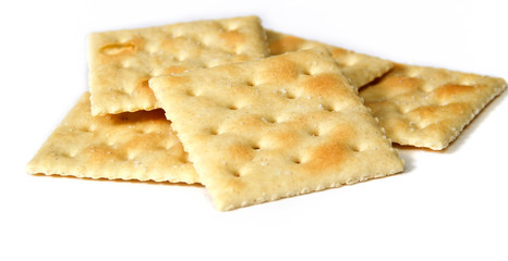 Eye level view of small stack of saltine or soup crackers, also known as soda crackers over white.