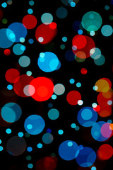 assorted size red and light blue bokeh mixture isolated on black background for festive cards