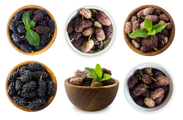 Set of mulberries. Mulberries in a wooden bowl with copy space for text. Black and purple mulberry on white background. Ripe and tasty mulberry isolated on white background. Top view.