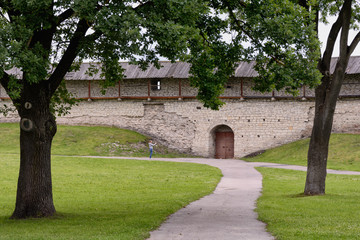 Fototapeta na wymiar Fragment of the yard and fortress wall of the ancient Pskov Kremlin, Russia