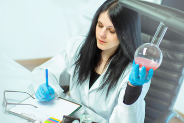 Genetic laboratory. A female geneticist writes the results of the expertise on fatherhood....