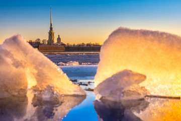 Fototapeta premium Saint-Petersburg. Russia. View of the Peter and Paul fortress through the ice on the Neva. Spring ice melts on the Neva river. Ice drift in Petersburg. Early morning Petersburg. Russian museums.