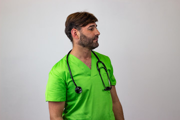 Portrait of male veterinary doctor in green uniform with brown hair looking jealous, facing...
