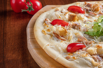 Pizza Caesar close-up on a wooden Board.