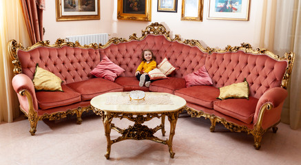 Girl toddler in a living room with baroque decor.