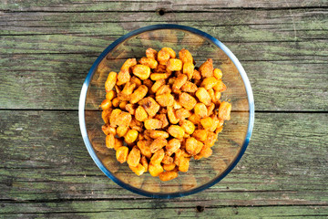 spiced fried corn in glass bowl on wooden background