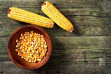 Maize and ceramic bowl on wooden table