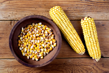 Maize and ceramic bowl on wooden table