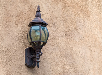 vintage carriage lamp on an exterior beige wall with copy space