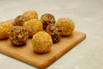 Healthy energy balls made of oats, walnuts, dates and raisins or walnuts, dried apricots and coconut flakes. Image with copy space, selective focus