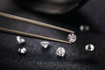Gemstone clamped in tweezers. Jewelry inserts close-up