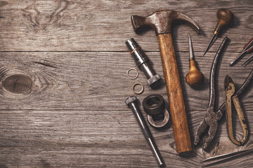 Various tools for jewelry works on a wooden table with copy space