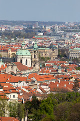 Obraz premium Spring Prague City with St. Nicholas' Cathedral and the green Nature and flowering Trees, Czech Republic