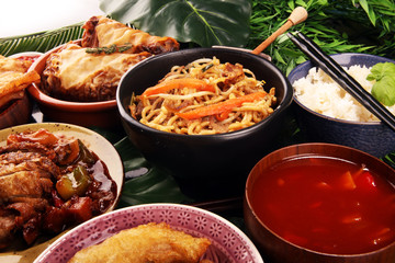Assorted Chinese food set. Chinese noodles, fried rice, peking duck, dim sum, spring rolls. Famous Chinese cuisine dishes on table. Chinese restaurant