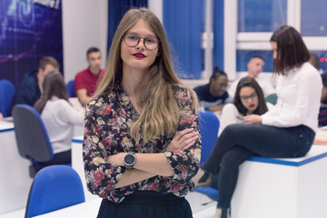 Students life on the campus.Portrait of female college student smiling and looking at camera during class in the classroom.